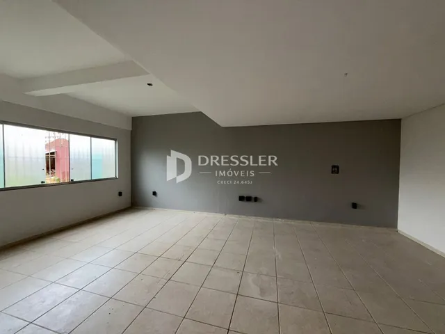 Interior de uma sala com piso de cerâmica e grande janela.