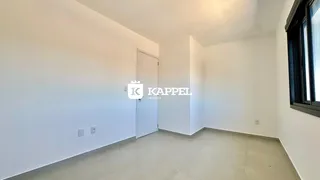 Hall de entrada com paredes brancas e porta branca.