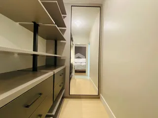 Hall com estantes e espelho refletindo um corredor interno.