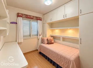 Quarto com cama e armários brancos em um imóvel.
