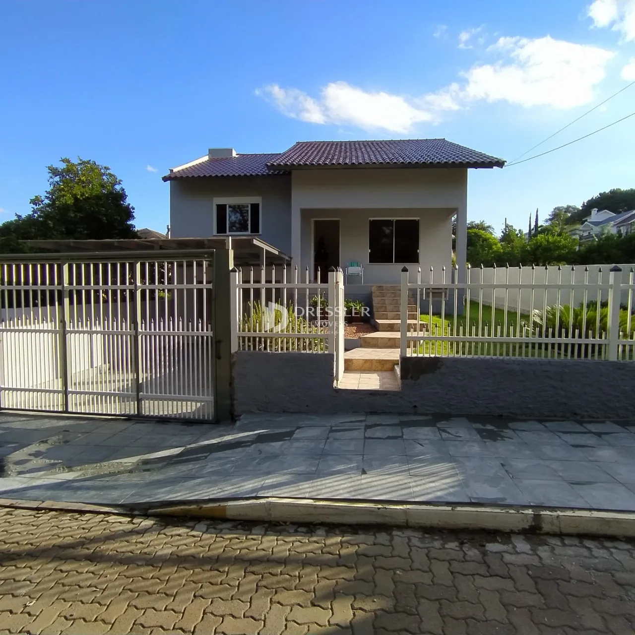 Fachada de uma casa em Lajeado, Brasil, com cerca e portão de metal.