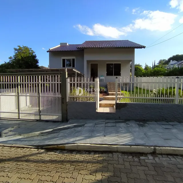 Fachada de uma casa em Lajeado, Brasil, com cerca e portão de metal.