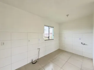 Foto de um ambiente interno com paredes brancas e piso de cerâmica.