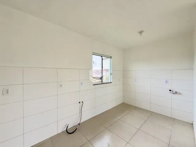 Foto de um ambiente interno com paredes brancas e piso de cerâmica.
