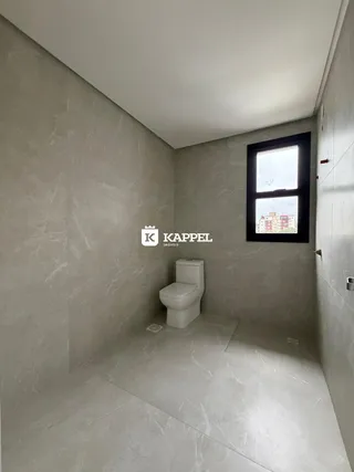 Foto de um banheiro moderno com paredes de mármore cinza e uma janela.