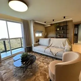 Sala de estar com sofá e vista para o exterior.