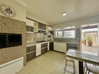Vista da cozinha com revestimento de azulejos e janela de uma residência em Lajeado.