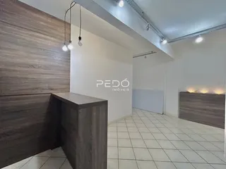 Interior de uma sala de estar com revestimento de madeira e piso de cerâmica.