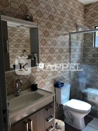 Foto de um banheiro com pia e vaso sanitário e box de vidro.