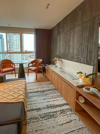 Sala de estar com piso de madeira e janela com vista da cidade.