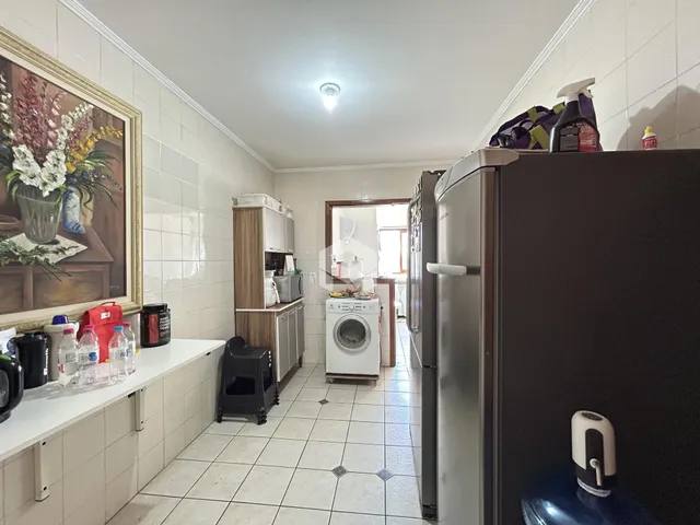 Interior de uma cozinha com revestimento de cerâmica e armários.