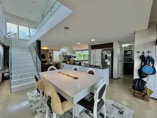 Interior de uma sala de jantar com cozinha aberta em uma residência.