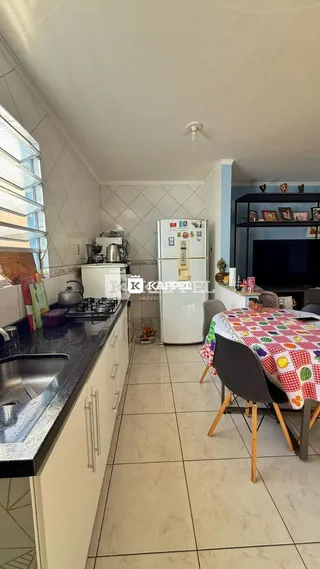Cozinha com armários brancos e piso de cerâmica.