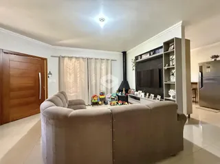 Foto da sala de estar com sofá e parede de TV moderna.