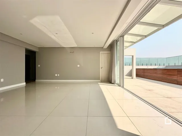 Interior de uma sala com piso claro e acesso a uma área externa.