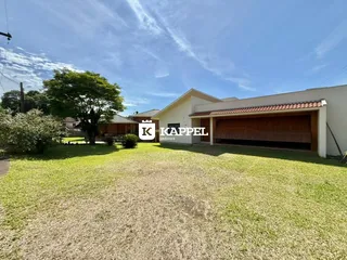Vista externa de uma casa com jardim gramado e garagem em Lajeado.