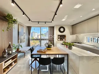 Uma sala de jantar moderna com cozinha integrada e vista para a cidade.