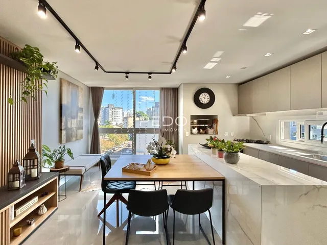 Uma sala de jantar moderna com cozinha integrada e vista para a cidade.