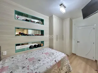 Quarto com cabeceira e armário branco em um imóvel no Brasil.