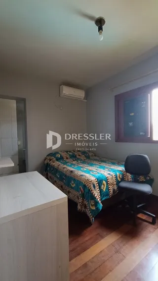 Foto de um quarto com cama e piso de madeira.