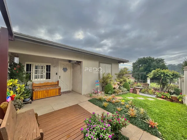 Fachada de uma casa em Lajeado, Brasil, com jardim e deck de madeira.