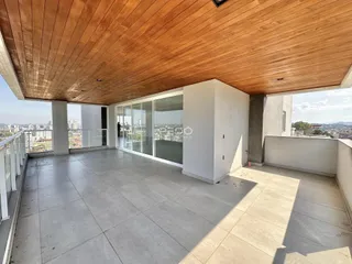 Vista da varanda com piso de cerâmica e teto de madeira.