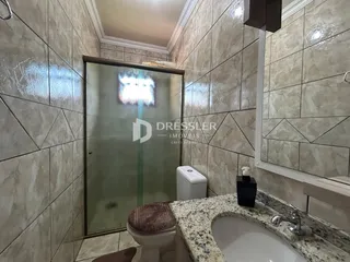 Foto de um banheiro com revestimento de cerâmica e box de vidro.