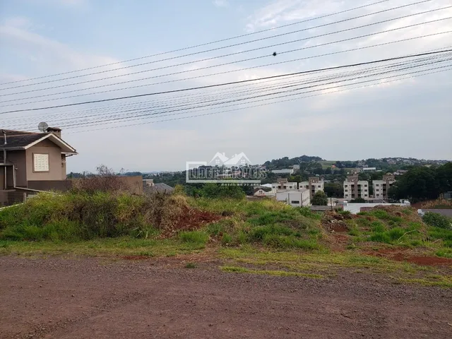 Vista da paisagem rural com vegetação e construções ao fundo.
