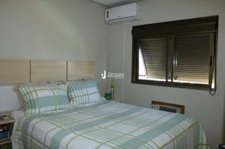 Quarto com cama e janela de madeira.