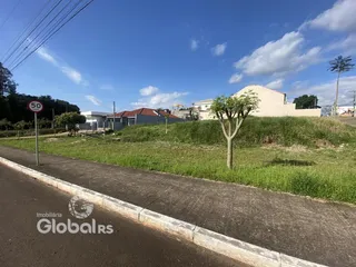 Vista externa de uma propriedade com gramado e estrada no primeiro plano.