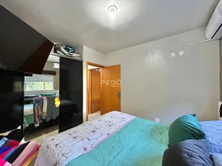 Quarto com cama e portas de madeira em uma residência.