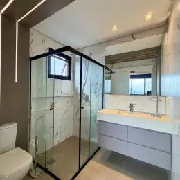 Enclosure de vidro com acabamento moderno em um ambiente interno.