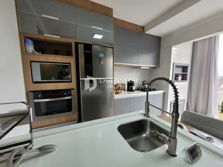 Cozinha moderna com armários e eletrodomésticos em aço inoxidável.