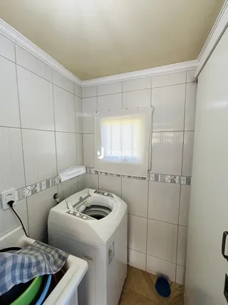Banheiro com revestimento cerâmico nas paredes brancas.