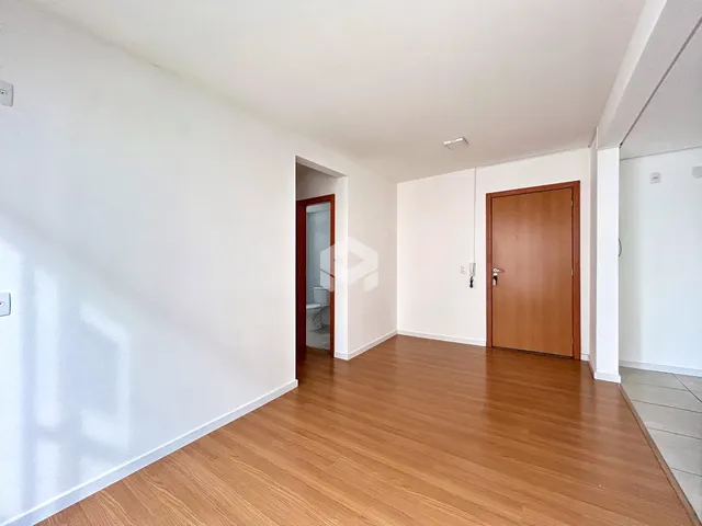 Hall de entrada com piso de madeira e paredes brancas.