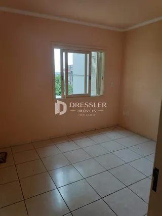 Vista interna de uma sala com piso de cerâmica e paredes em tom claro.