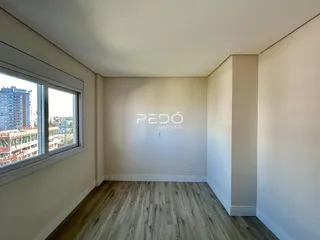Vista interna de um ambiente com piso de madeira e janela.