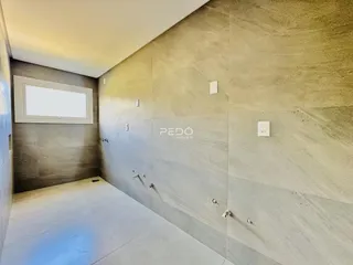 Vista de um corredor interno com paredes texturizadas em um imóvel em Lajeado.