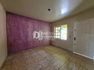 Uma sala com piso de cerâmica clara e parede roxa.