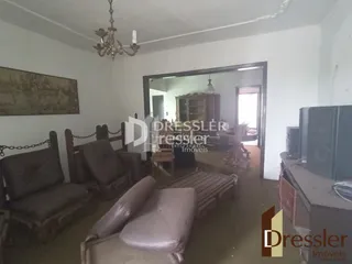 Ambiente interno de uma sala com decoração clássica e móveis de couro.