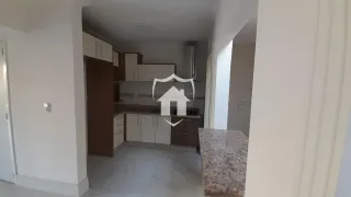 Vista interna de um corredor com armários de cozinha e piso claro.
