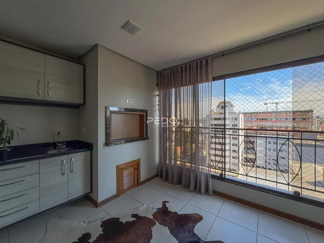 Sala de estar com piso de cerâmica e grande janela com vista para a cidade.