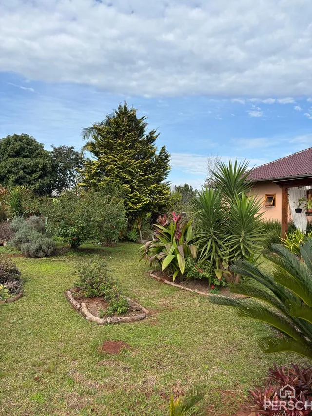 Paisagem externa com gramado e vegetação em uma propriedade.
