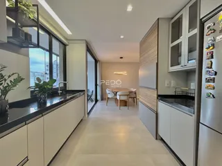 Interior moderno de uma sala de estar com cozinha integrada em Lajeado.