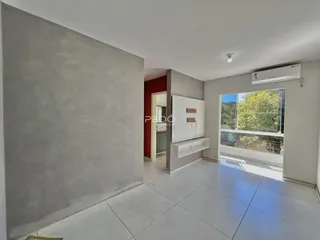 Vista interna de uma sala com parede cinza e porta vermelha.