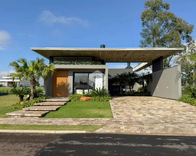 Fachada moderna de uma residência em Lajeado, Brasil, com jardim e entrada pavimentada.