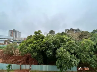 Vista externa da propriedade com vegetação densa e cerca de arame.