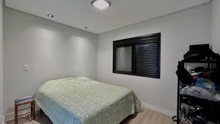 Quarto com cama coberta e janela escura.