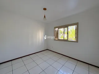 Vista interna de um cômodo com piso de cerâmica e janela.