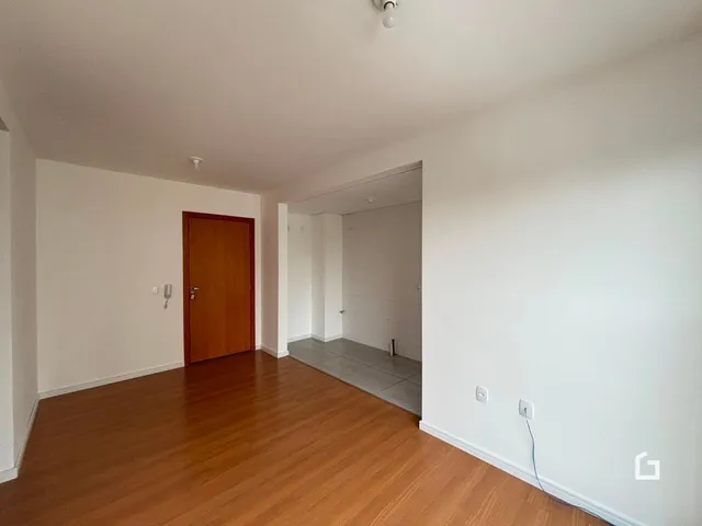 Interior de um ambiente com piso de madeira e porta de madeira.